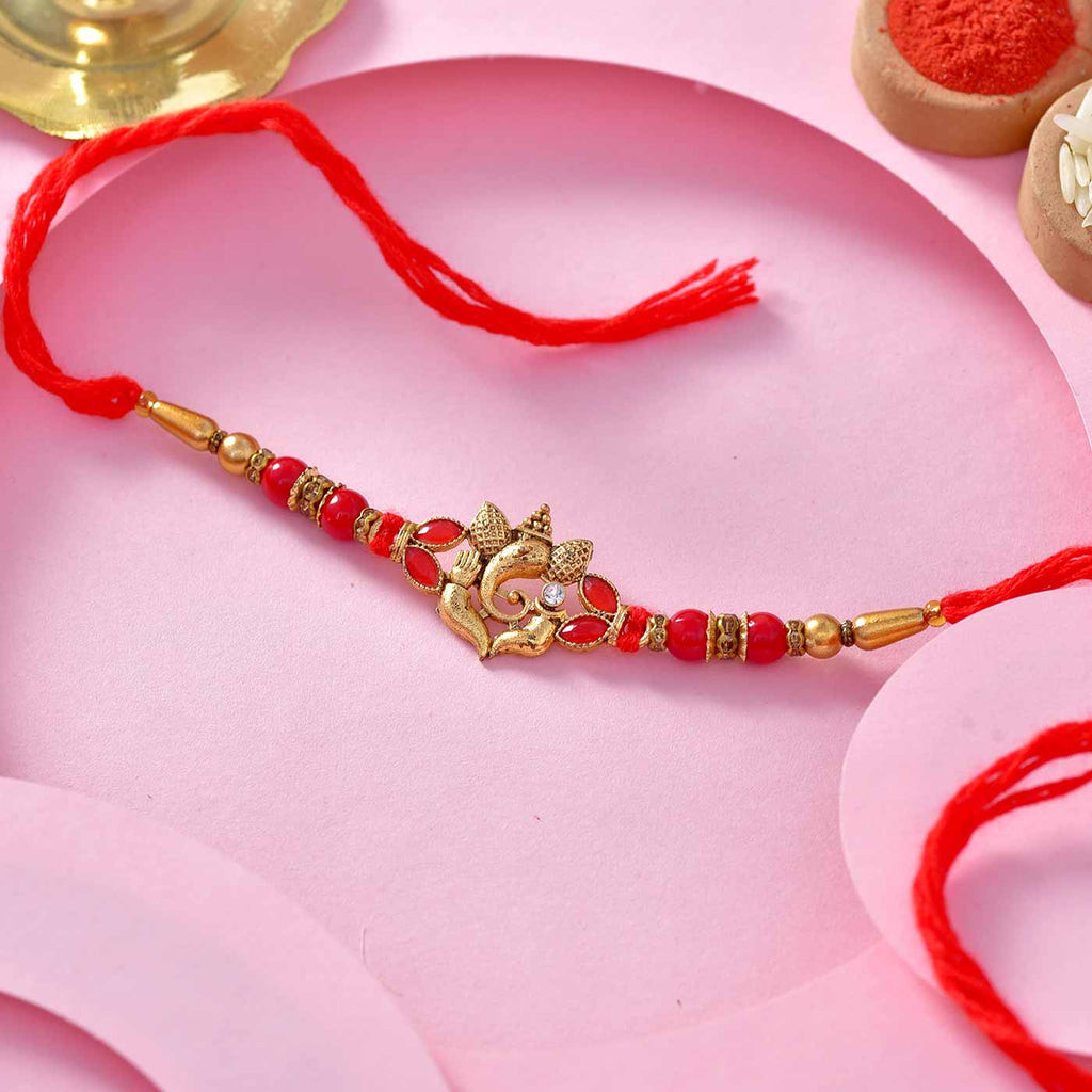 Fancy Metallic Ganesha And Red Beads Rakhi